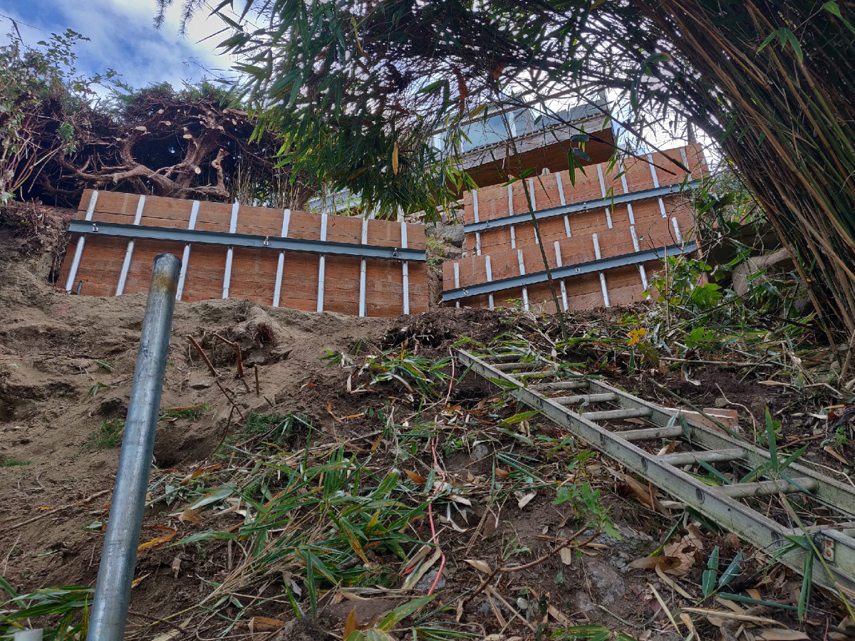 Pin pile erosion wall with timber lagging holding a steep Seattle slope