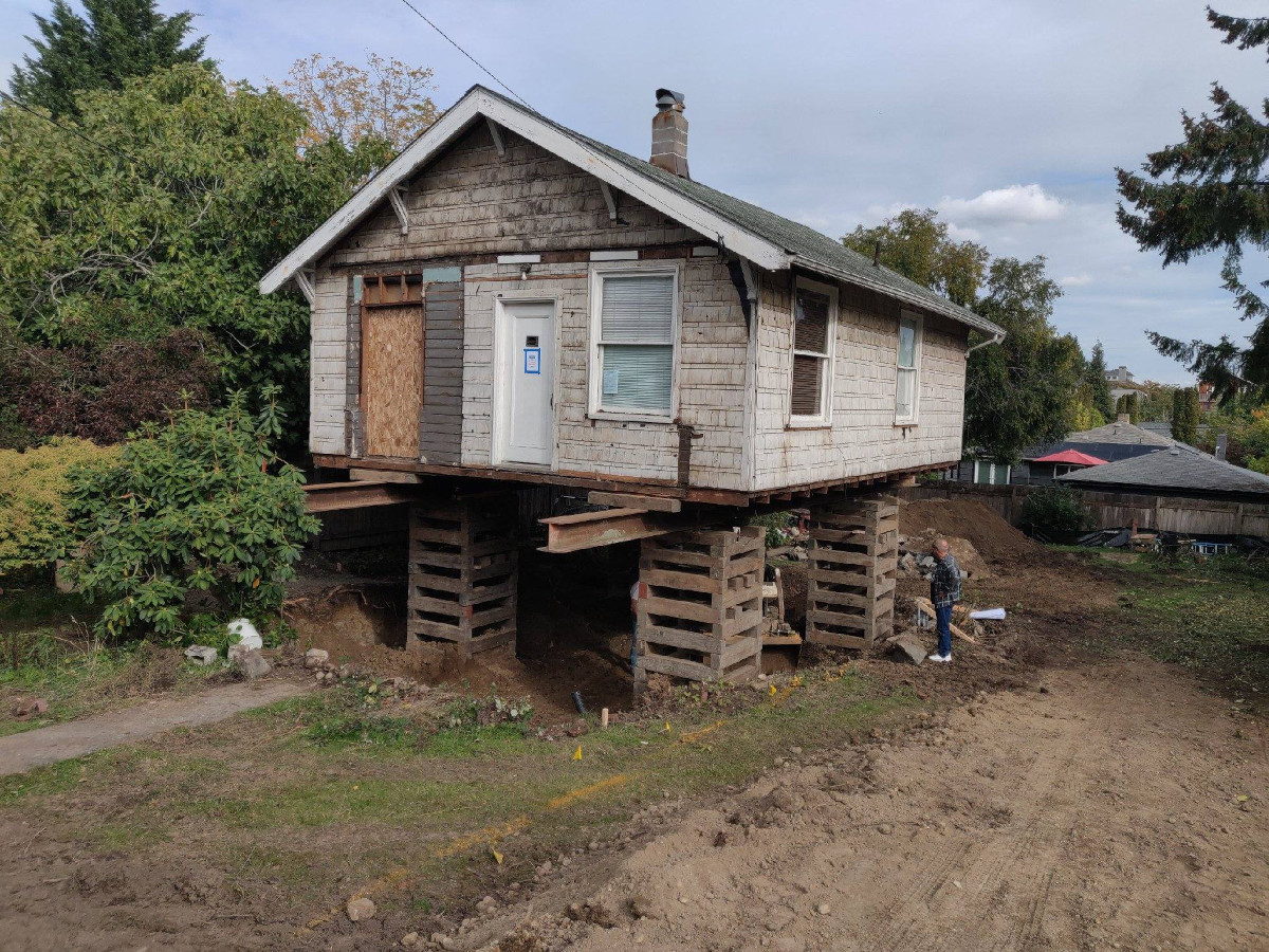 The same rambler carried on steel I beams while its new foundation is built