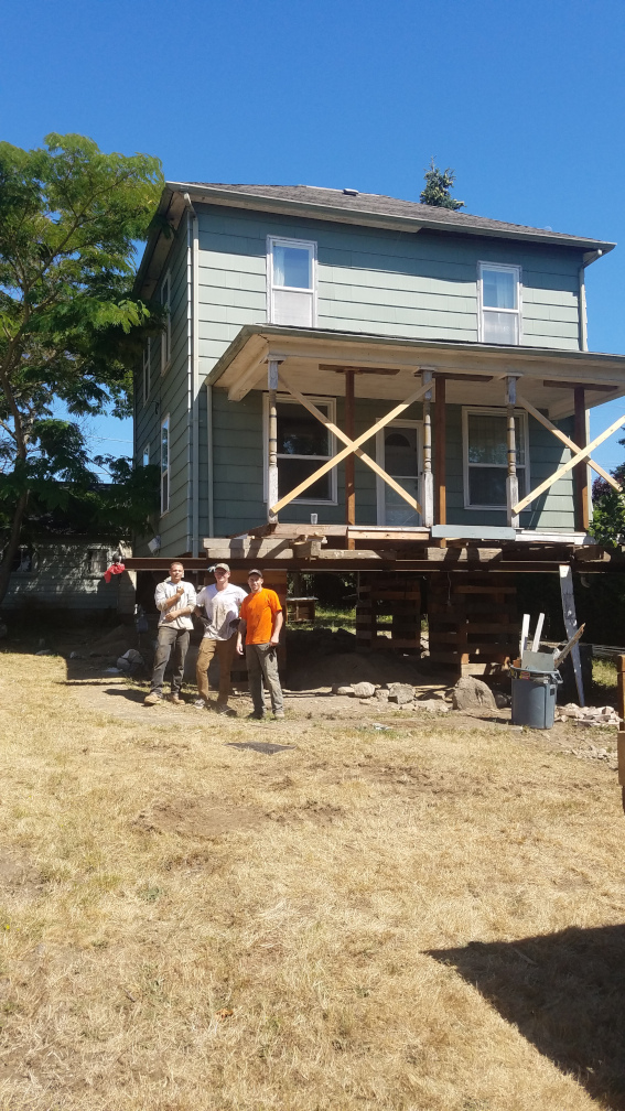 Two-story home held on cribbing while a new first floor is built beneath it