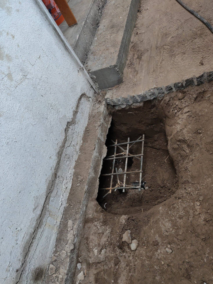 Pin pile excavation and rebar cage opened alongside an existing Seattle footing