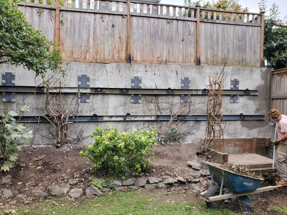 Retaining wall reinforced with steel walers and anchors behind a Seattle home